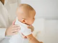 Delikatna pozycja do odbijania noworodka, gdzie dziecko jest podtrzymywane przez rodzica.