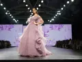 Modelka prezentuje suknię haute couture z muślinu i tiulu na pokazie mody.