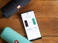 Dwa głośniki JBL Flip 4, czarny i zielony, połączone przez aplikację JBL Connect+ w trybie stereo.