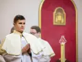 Junge Männer in festlicher Kleidung, die auf ihre Diakon Ausbildung vorbereitet werden. Sie stehen betend in einer Kirche.