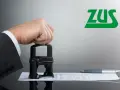Dłoń w garniturze przyciska pieczątkę do dokumentu. Logo ZUS. Temat: sprzeciw wobec orzeczenia lekarza orzecznika ZUS - forum.