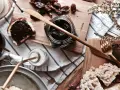 Słodkie śniadanie: kromka chleba z kremem czekoladowym, słoiczek z ciemnym dżemem, daktyle i ciastka. Idealna nutella bez orzechów!