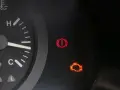 Kontrolka silnika świeci się, wskazując błąd DTC P0010 w Renault. Obok świeci się kontrolka hamulca ręcznego.