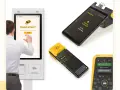 Mann bucht per Touchscreen einen Taxi-Butler. Mehrere Geräte zeigen Buchungsbestätigung und Taxi-Status.