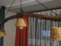 Jak odnowić stary drewniany żyrandol? Ta rustykalna lampa z gałęzi i plecionych kloszy z pewnością doda uroku wnętrzu.