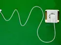 Cavo bianco collegato a una presa elettrica dorata. Si può lasciare il caricabatterie attaccato per avere sempre energia.
