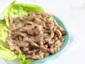 Straccetti di manzo succulenti serviti su foglie di lattuga fresca, un piatto invitante e saporito.