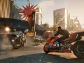 Postapokaliptyczna scena z gry Cyberpunk 2077: mężczyzna na motocyklu strzela do samochodu w futurystycznym mieście.