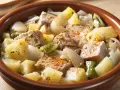 Un delicioso marmitako de atún con patatas, pimientos y cebolla en una cazuela de barro.