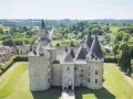 Le château de Bonneval, un joyau médiéval, se dresse fièrement au milieu d'un paysage verdoyant, entouré d'un village pittoresque.