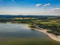 Letnie słońce nad **Jeziorem Chańcza**. Tłumy plażowiczów, zielone lasy i pola tworzą malowniczy krajobraz.