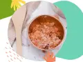 Miedziana miseczka z naturalnym peelingiem do twarzy, obok drewniana łyżeczka i ściereczka.