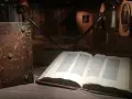 W muzeum diecezjalnym w Pelplinie eksponaty takie jak stary, oprawny księgozbiór i otwarta księga z tekstem przyciągają wzrok zwiedzających.