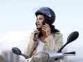 Donna con casco da moto nero, pronta a partire. Non è un luogo dove si buttano i caschi da moto, ma un simbolo di sicurezza.