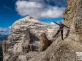 Kobieta na via ferrata, pokonująca skalną ścieżkę z ubezpieczeniem. To właśnie jest ferrata co to za przygoda!