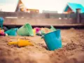 Jouets de plage dans le sable, prêts pour une demande de stage pratique BAFA.