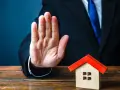 Main tendue, un homme en costume bloque une petite maison. Mon ex refuse la désolidarisation, le bien reste bloqué.