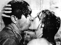 Una pareja se besa apasionadamente bajo la ducha, un momento íntimo que captura la esencia de qué es un beso francés.