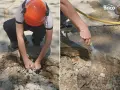 Preparando el área para reparar suelo de hormigón exterior. Se retiran escombros y se humedece la zona.