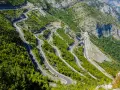 W serpentynach albania trasa pnie się po stromych zboczach gór, otoczona bujną zielenią.