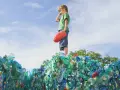 Chłopiec stoi na górze sterty plastikowych butelek, zastanawiając się, co to za pla.