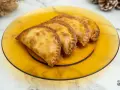 Empanadillas doradas y crujientes, recién hechas en freidora de aire, servidas en plato ámbar.