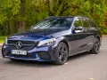 Granatowy Mercedes C klasa W205 kombi zaparkowany na tle jesiennego lasu.