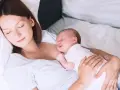 Matka śpi z dzieckiem przy piersi, doświadczając piękna laktacji.
