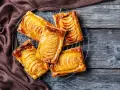 Deliziosi dolci con pasta sfoglia e mele caramellate, disposti su una gratella, su un tavolo di legno rustico.