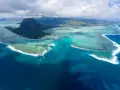 Majestatyczny Le Morne Brabant góruje nad turkusową laguną Mauritiusa. Woda mieni się odcieniami błękitu i zieleni, a białe fale rozbijają się o rafę.