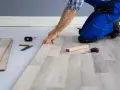 Installazione di un nuovo pavimento in laminato, un passo fondamentale per come isolare il pavimento dal freddo. Attrezzi da lavoro a portata di mano.