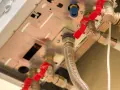 Dettaglio delle valvole rosse per chiudere acqua caldaia e tubazioni in rame e plastica.