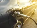 Tankowanie auta. Zastanawiasz się, ile kosztuje gaz do auta? Słońce odbija się od karoserii podczas tankowania.
