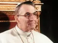 Papież Jan Paweł I, który był papieżem przed Janem Pawłem II, w białej sutannie i okularach.