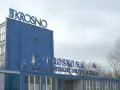 Niebieski budynek z napisem "KROSNO S.A. KROŚNIEŃSKIE HUTY SZKŁA".