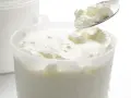 Cuillère de fromage blanc crémeux, prêt à être dégusté. La différence faisselle et fromage blanc réside dans leur texture.