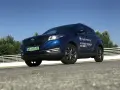 Niebieski SUV Seres 3 zaparkowany na zewnątrz, z widocznym logo i napisem.