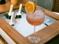 Orzeźwiający Aperol z pomarańczą i butelkami prosecco w lodzie. Idealne na letnie popołudnie.