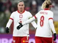 Piłkarki Polski w białych strojach z orłem na piersi, gotowe do meczu z Irlandią.