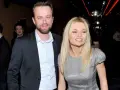 Julia Balsewicz w srebrnej sukience i mężczyzna w czarnym garniturze uśmiechają się do obiektywu.