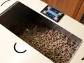 Serbatoio pieno di pellet, alcuni sembrano un po' troppo lunghi per la stufa. Il display digitale mostra 19 e 25.