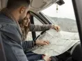 Para planować kolejny etap podróży kamperem, para przegląda mapę.