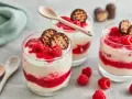 Schokokuss Dessert mit Mascarpone, Himbeeren und Schokowaffel-Keksen in Gläsern, garniert mit frischen Himbeeren.