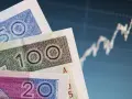 Polskie banknoty 20, 50, 100 zł na tle wykresu giełdowego. Bankowy fundusz gwarancyjny chroni depozyty w bankach.