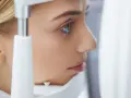 Esame oculistico: una donna con linee blu che indicano la pseudofachia dell'occhio.