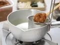 Łyżka z pastą miso trafia do bulionu. Tak przygotowuje się bazę do zupy, pytasz miso co to? To fermentowana pasta sojowa.