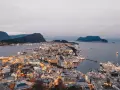 Vacker stad vid vattnet i Norge, med upplysta hus och berg i bakgrunden. En dröm att bila i Norge.