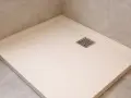 Un receveur résine ou céramique moderne, épuré, avec une grille d'évacuation carrée. Parfait pour une douche à l'italienne.