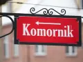 Czerwona tabliczka z napisem "Komornik" i strzałką w lewo. Pamiętaj, czego nie może zabrać komornik z mieszkania!
