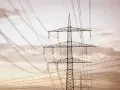 Linie energetyczne mwh przecinają niebo, tworząc geometryczny wzór na tle chmur.